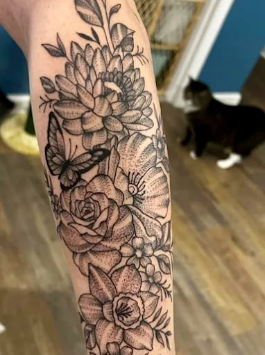 Black and gray floral tattoo with butterfly on forearm