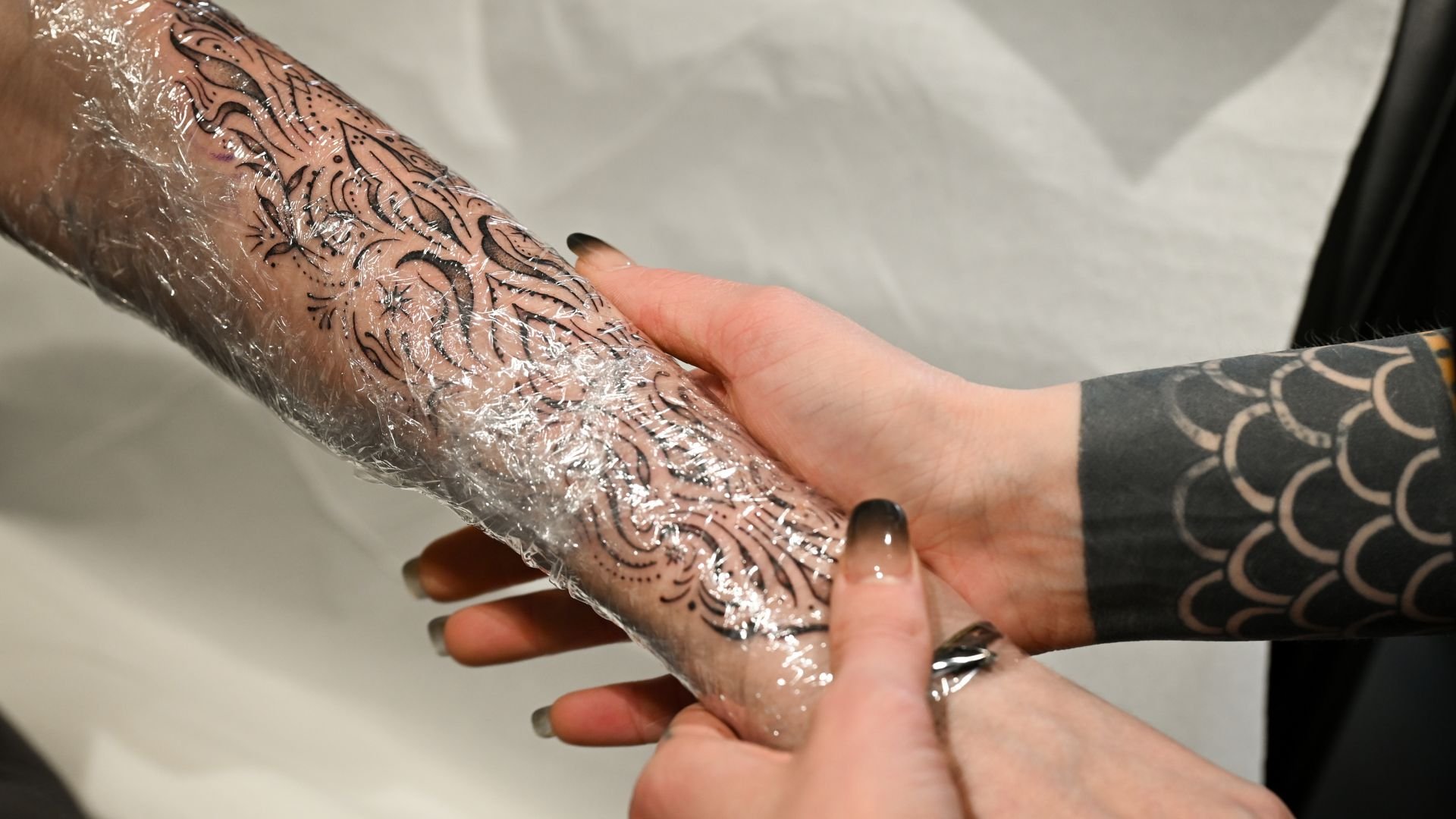 Newly applied intricate tattoo wrapped in protective plastic film
